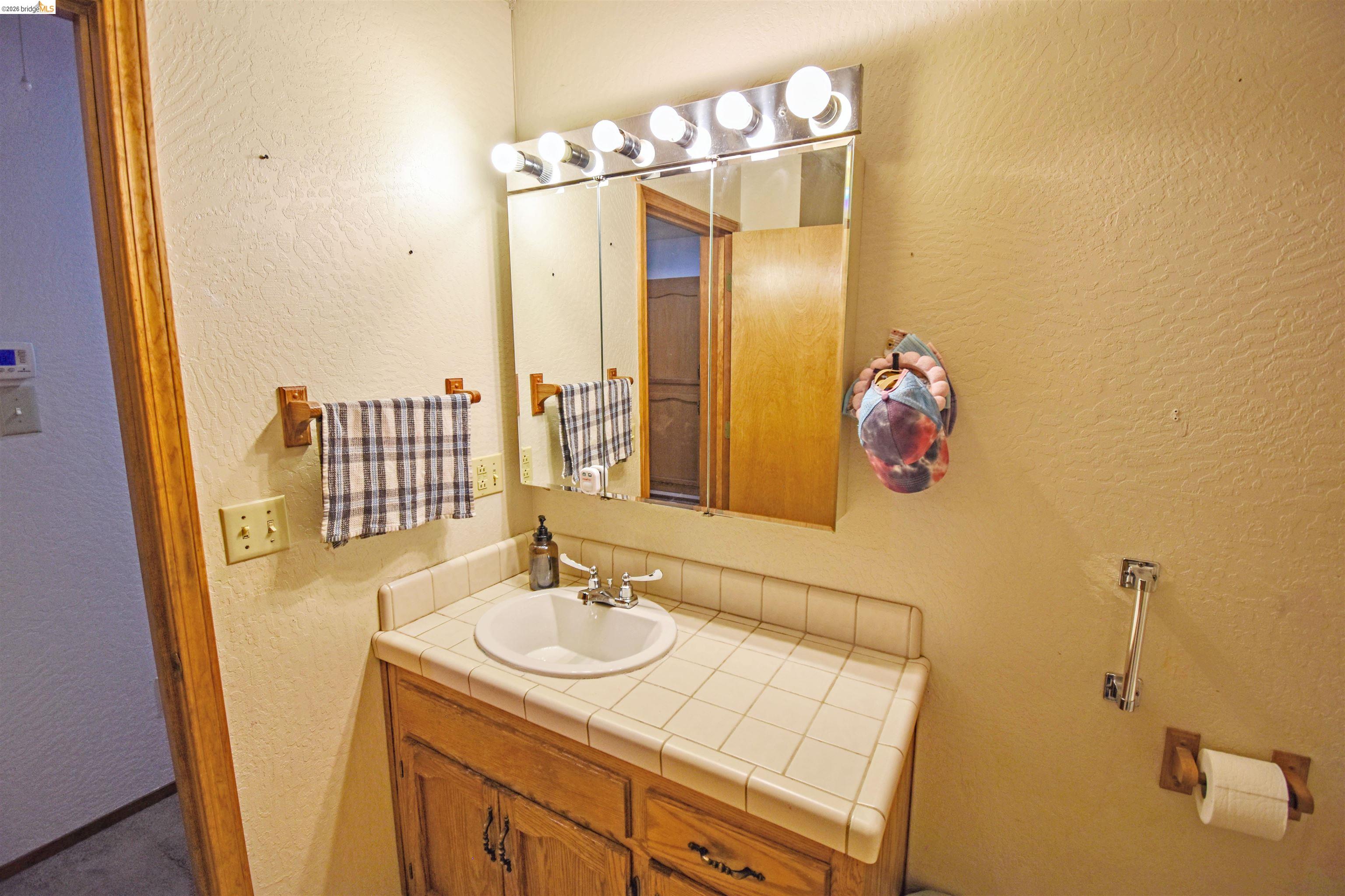 15 Roble Road Sonora, CA 95370 - Photo 21 of 44 Bathroom featuring a textured wall and vanity