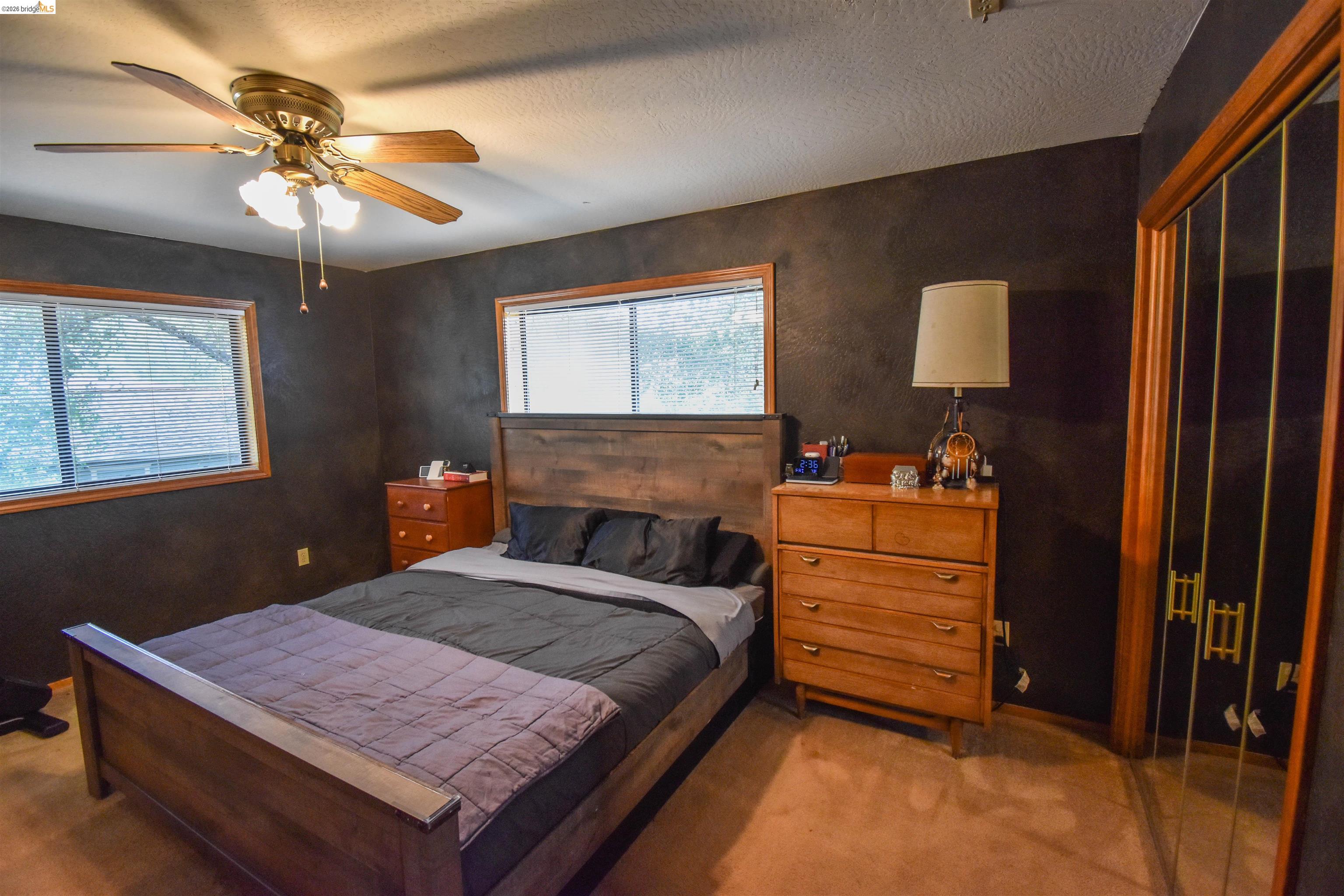 15 Roble Road Sonora, CA 95370 - Photo 24 of 44 Bedroom featuring carpet, ceiling fan, multiple windows, a closet, and a textured ceiling