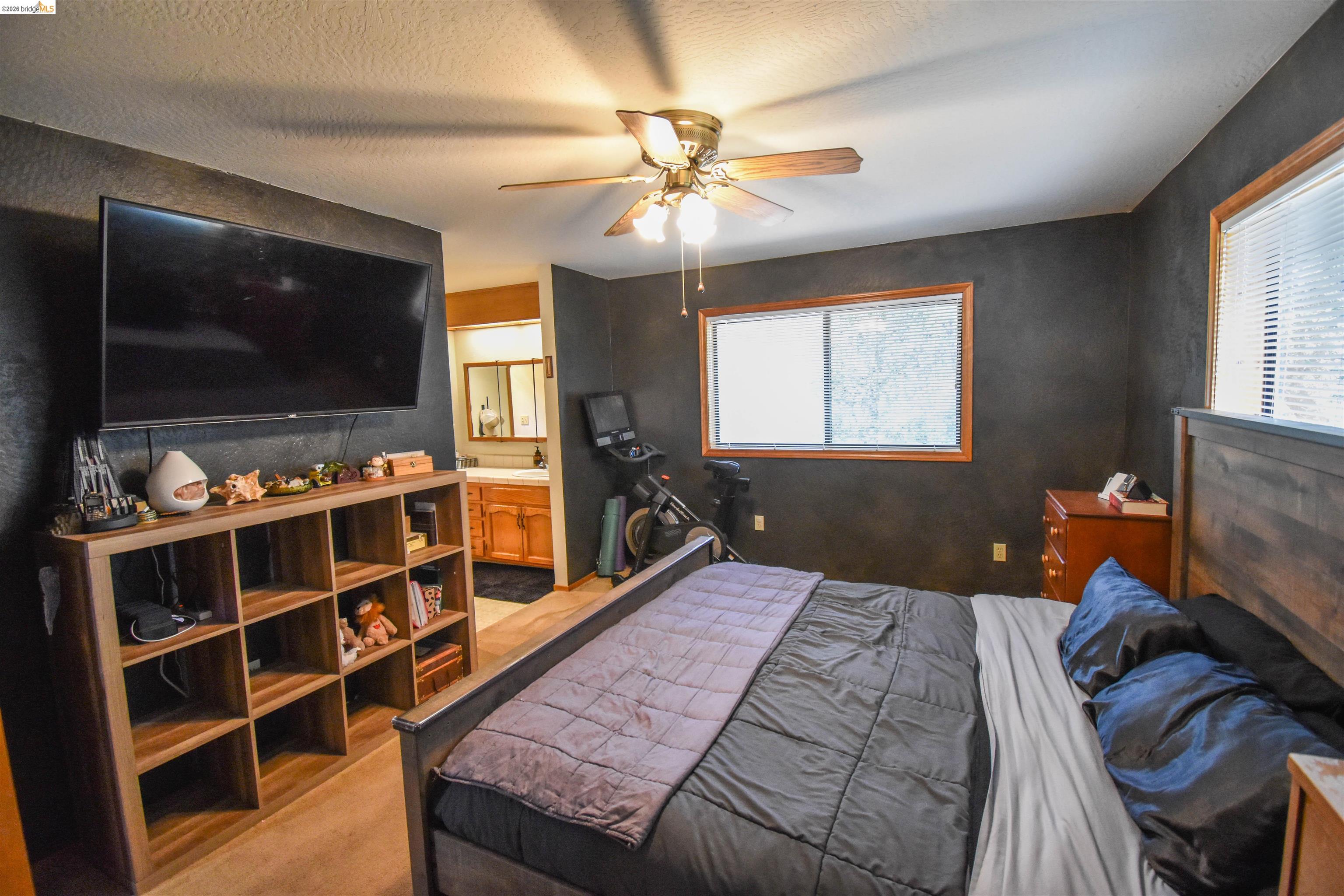 15 Roble Road Sonora, CA 95370 - Photo 25 of 44 Bedroom featuring ceiling fan, light carpet, ensuite bath, and a textured ceiling