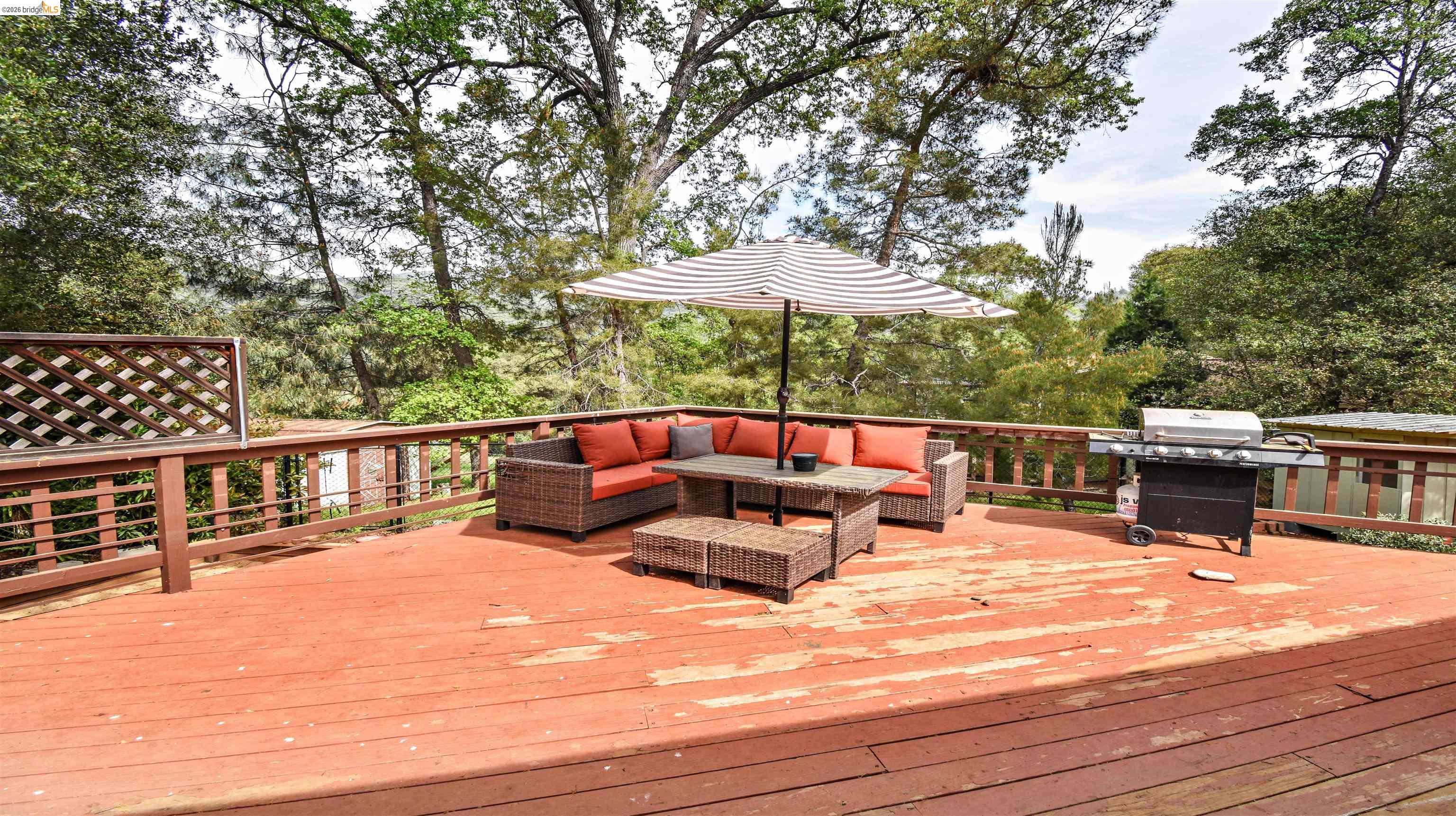15 Roble Road Sonora, CA 95370 - Photo 38 of 44 Wooden terrace featuring an outdoor lounge area, a grill, and view of wooded area