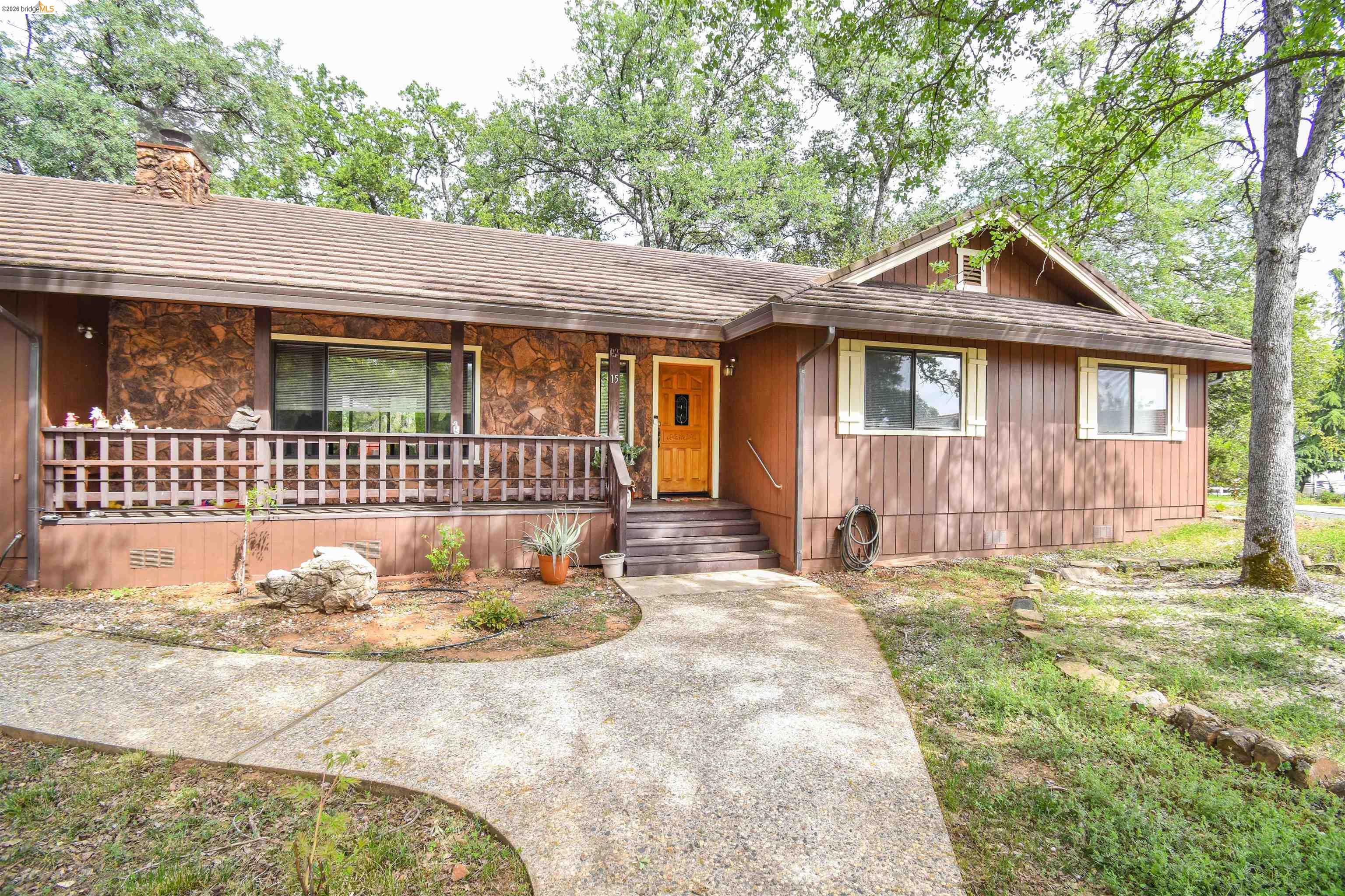 15 Roble Road Sonora, CA 95370 - Photo 4 of 44 View of front facade with covered porch, stone siding, and a chimney