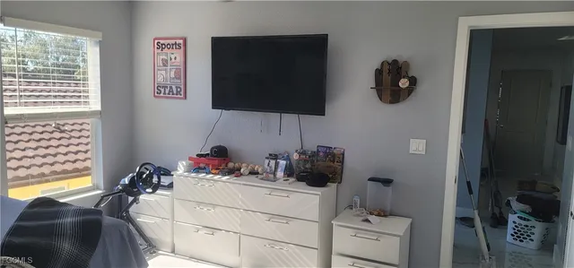 a bedroom with furniture and a flat screen tv