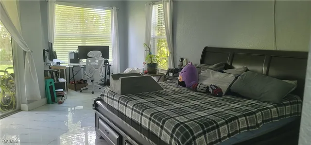 a bedroom with a bed and large windows