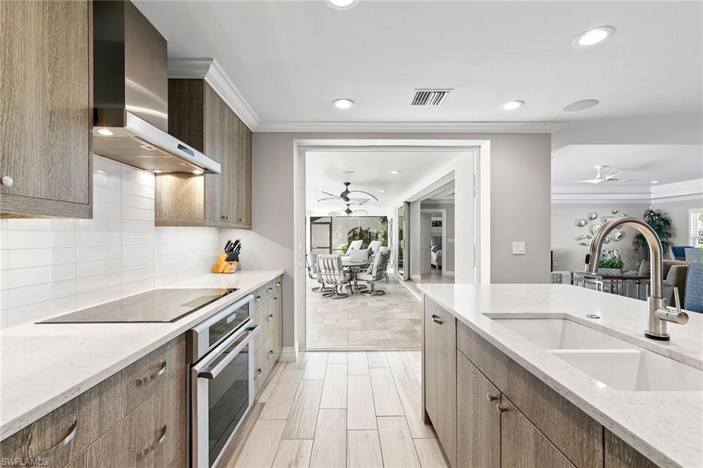 3720 Parkview Way Naples, FL 34103 - Photo 12 of 27 a kitchen with a sink stove and cabinets