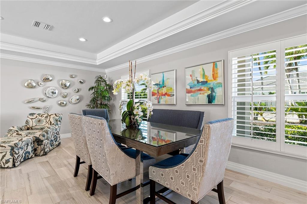 3720 Parkview Way Naples, FL 34103 - Photo 8 of 27 a dining room with furniture a large window and wooden floor