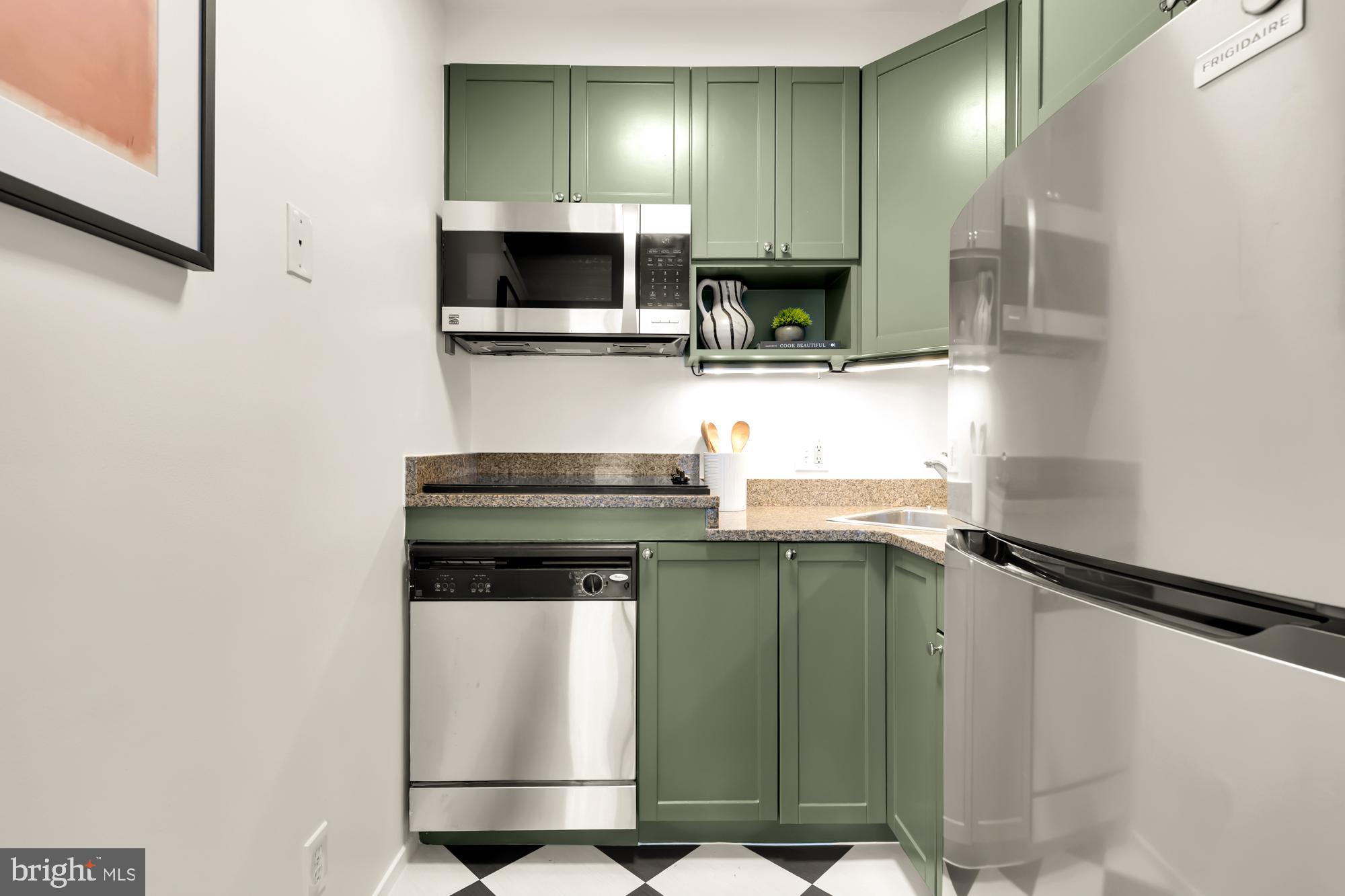 1844 Columbia Road Northwest, Unit 301 Washington, DC 20009 - Photo 7 of 21 a kitchen with stainless steel appliances granite countertop a refrigerator and a stove top oven
