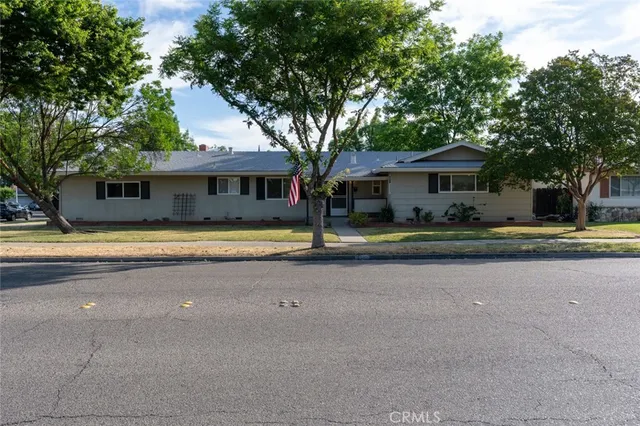 a front view of residential houses with yard and trees