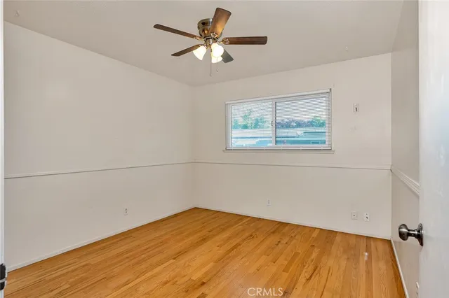 an empty room with a window and a ceiling fan