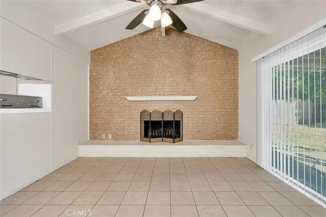 a view of an empty room with a fireplace and a window