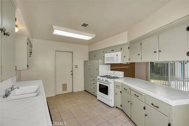 a kitchen with cabinets appliances and a sink