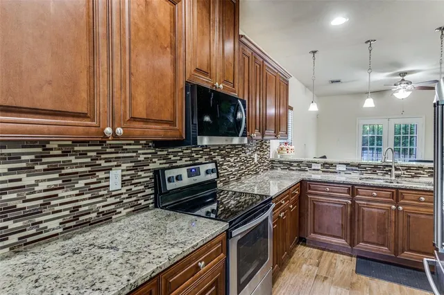 a kitchen with stainless steel appliances granite countertop a stove a sink and a microwave