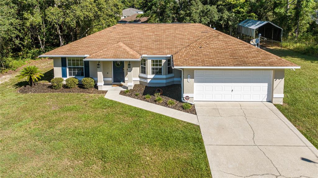 8734 North Circular Way Citrus Springs, FL 34434 - Photo 1 of 1 a front view of house with yard outdoor seating and barbeque oven