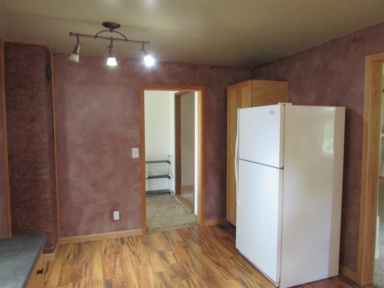504 Barry Road Rockford, IL 61109 - Photo 12 of 31 a view of a refrigerator in kitchen and an empty room with wooden floor