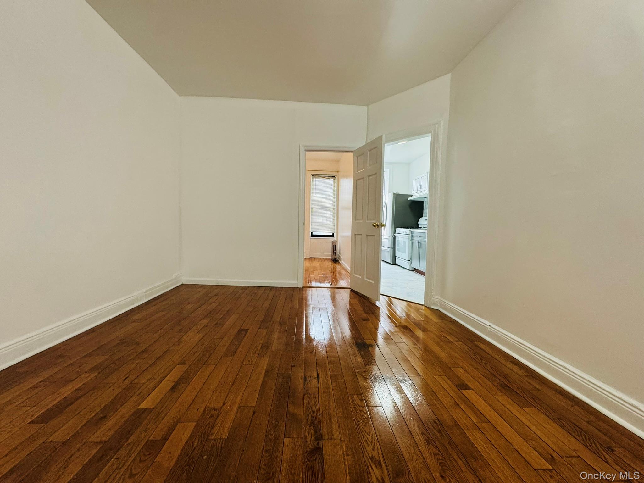 25-38 22nd Street, Unit 1 Queens, NY 11102 - Photo 12 of 19 an empty room with wooden floor and windows