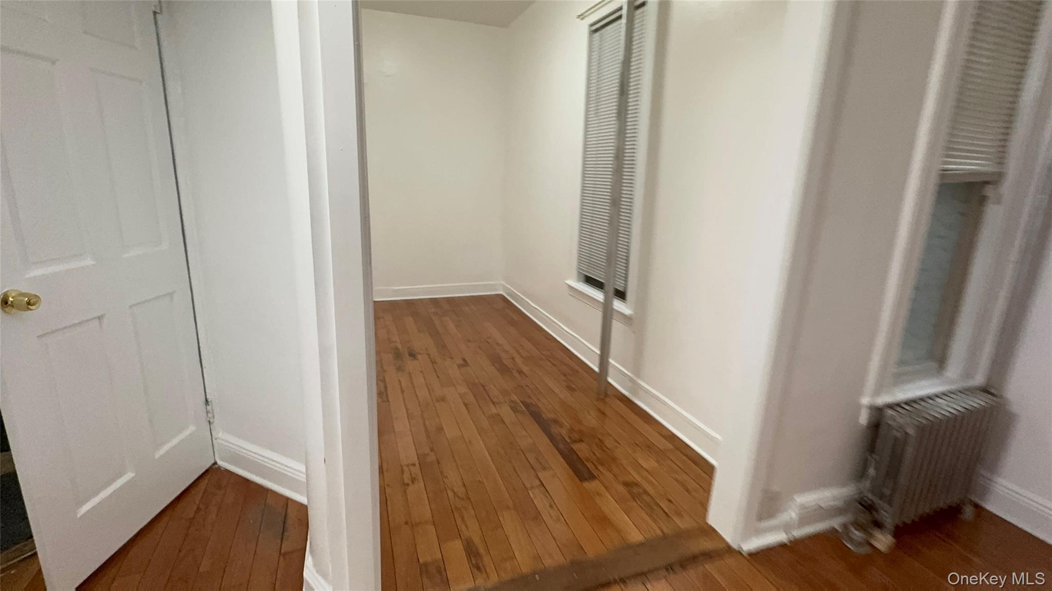 25-38 22nd Street, Unit 1 Queens, NY 11102 - Photo 16 of 19 a view of a hallway with wooden floor and staircase