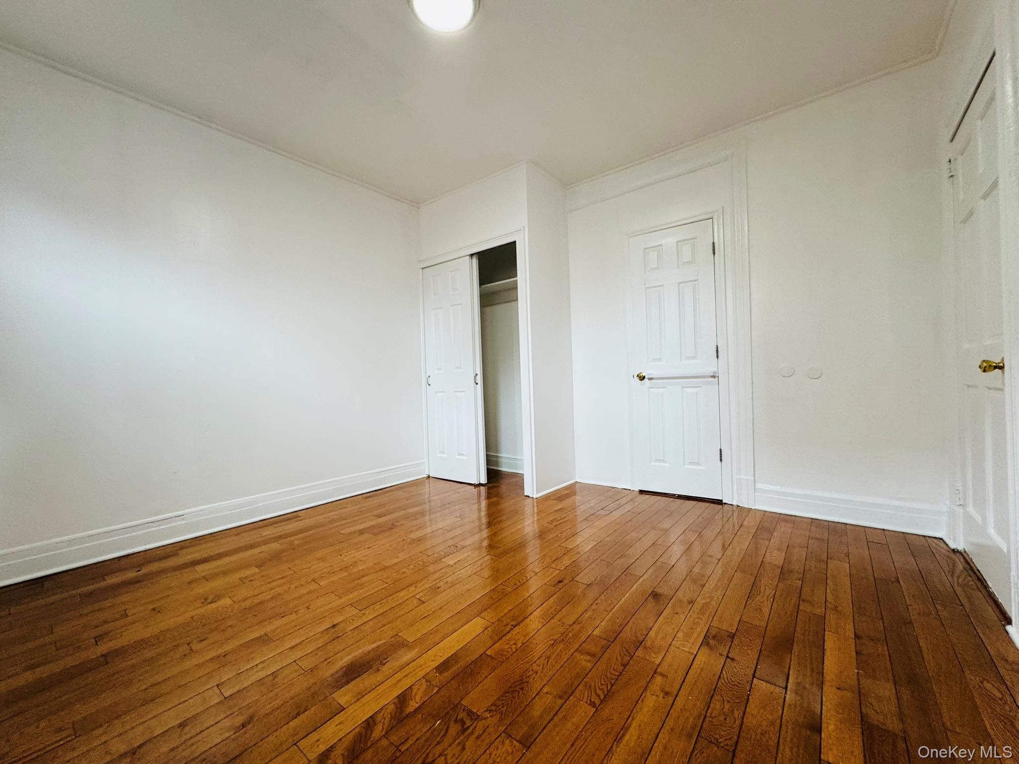 25-38 22nd Street, Unit 1 Queens, NY 11102 - Photo 18 of 19 a view of an empty room with wooden floor