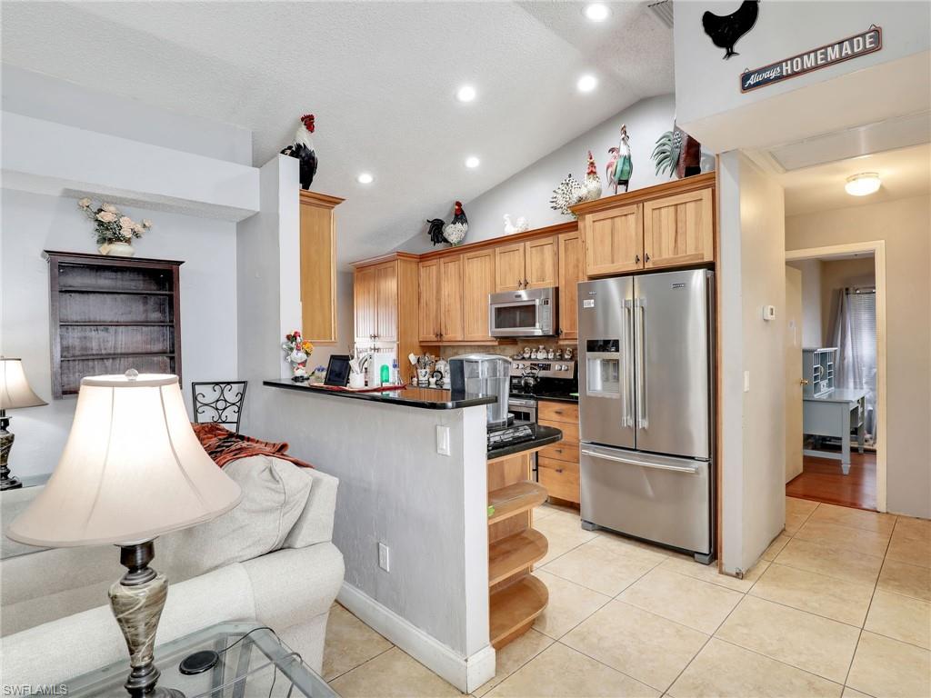 9083 Aster Road Fort Myers, FL 33967 - Photo 11 of 30 a kitchen with granite countertop a refrigerator and a stove top oven