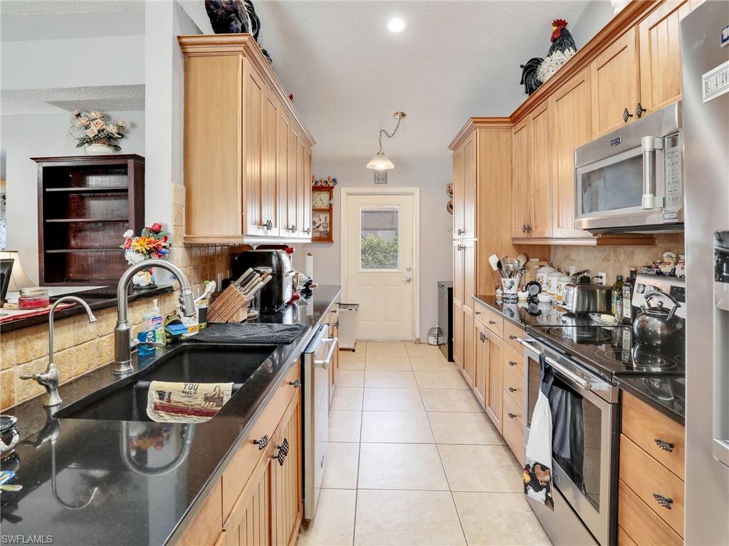 9083 Aster Road Fort Myers, FL 33967 - Photo 13 of 30 a kitchen with a stove sink and cabinets