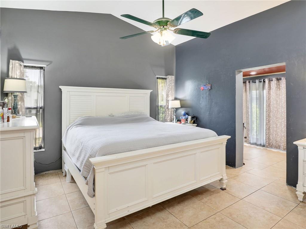 9083 Aster Road Fort Myers, FL 33967 - Photo 15 of 30 a bed room with a bed and a chandelier