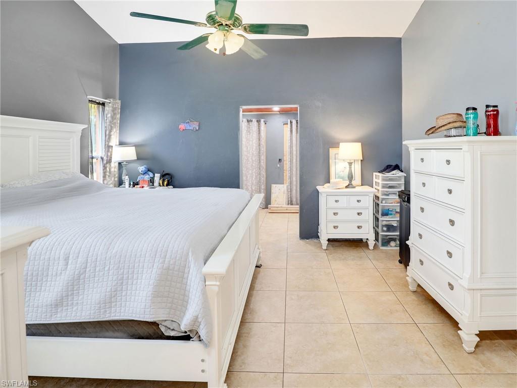 9083 Aster Road Fort Myers, FL 33967 - Photo 17 of 30 a bedroom with a bed and a chandelier