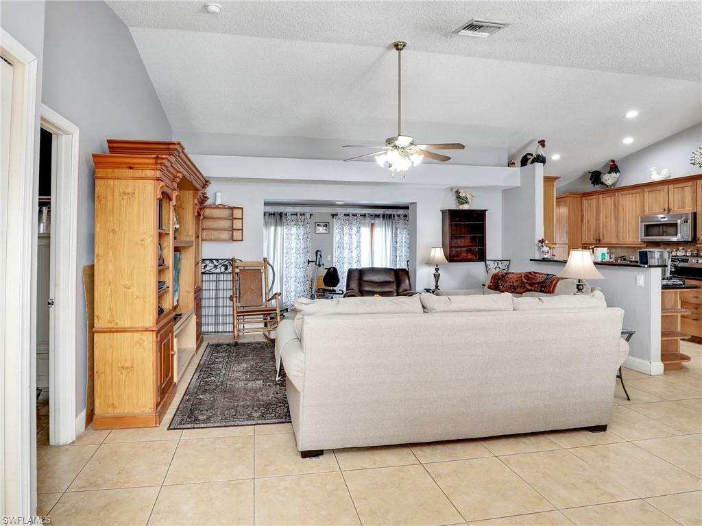 9083 Aster Road Fort Myers, FL 33967 - Photo 3 of 30 a living room with a couch a fireplace a counter top space and a view of living room