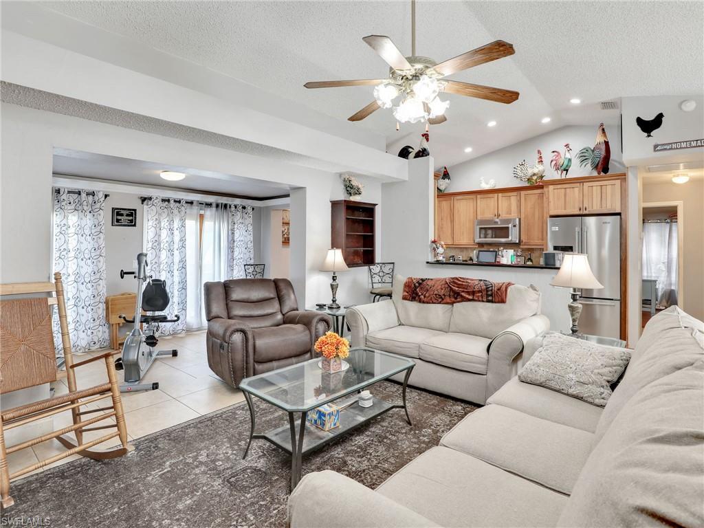 9083 Aster Road Fort Myers, FL 33967 - Photo 5 of 30 a living room with furniture kitchen view and a chandelier