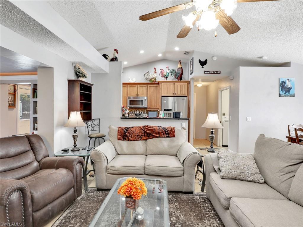 9083 Aster Road Fort Myers, FL 33967 - Photo 6 of 30 a living room with furniture kitchen view and a chandelier