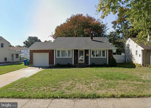 a view of a yard in front of a house with large tree