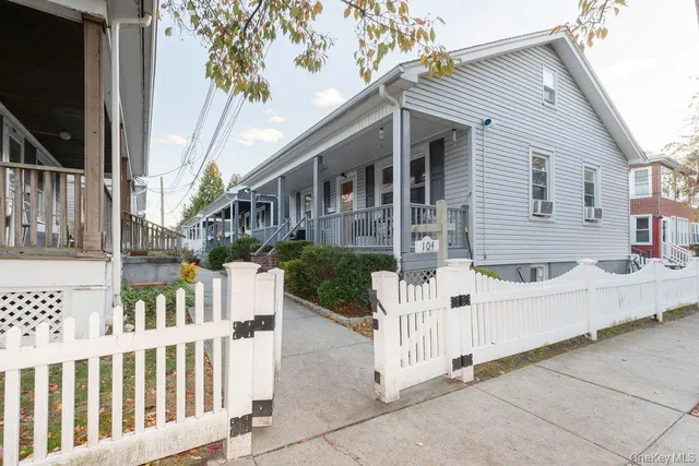 a white house that has tree in front of it