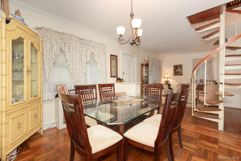 104 Fordham Street, Unit 5 Bronx, NY 10464 - Photo 9 of 27 a dining room with wooden floor a chandelier a wooden table and chairs