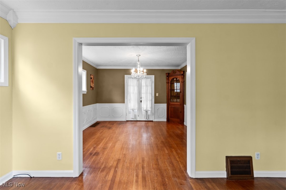 1492 Lyndhurst Road Lyndhurst, OH 44124 - Photo 8 of 32 Dining area featuring a chandelier, wood finished floors, crown molding, and wainscoting