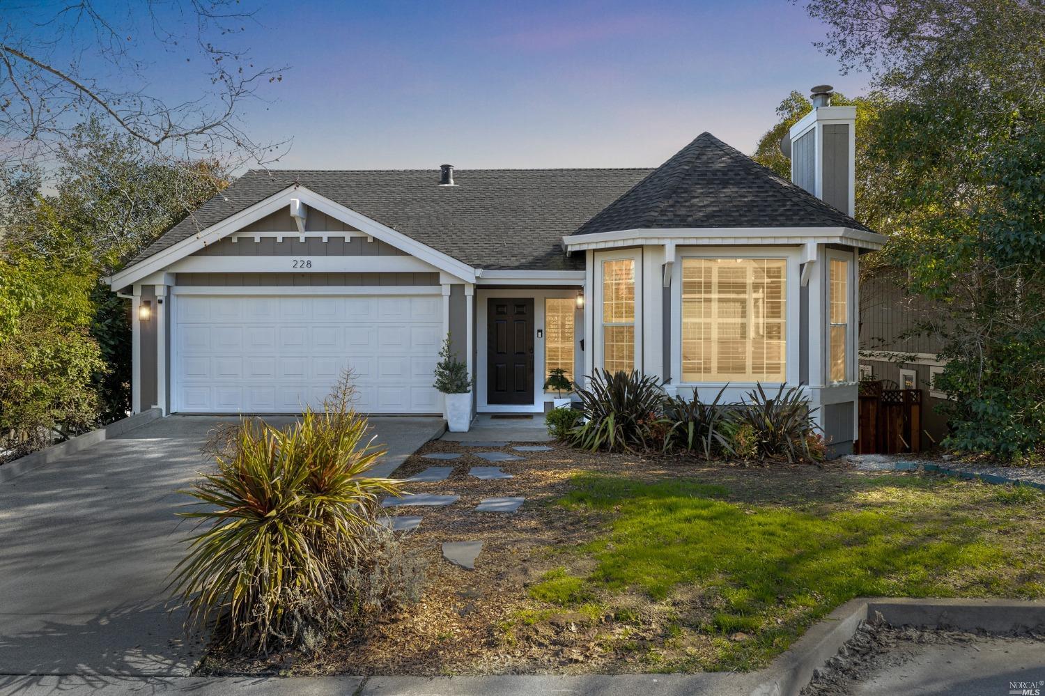 a front view of house with yard and trees in the background