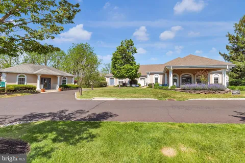 a view of house with garden and tall tress