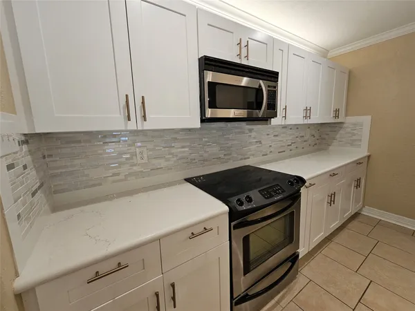 a kitchen with a sink a stove top oven and cabinets