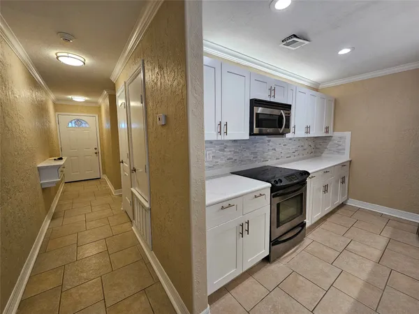 a kitchen with granite countertop white cabinets stainless steel appliances and a sink