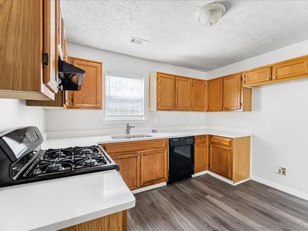 a kitchen with stainless steel appliances a sink a stove and cabinets