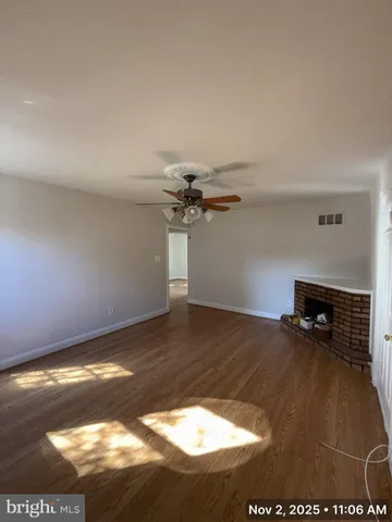 a view of a room with wooden floor and a ceiling fan