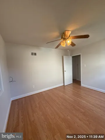 a view of an empty room and chandelier fan
