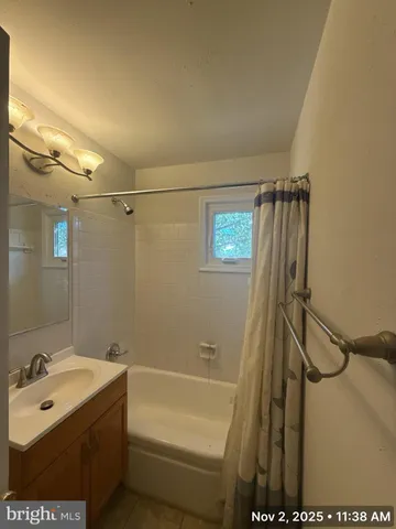 a bathroom with a tub a sink and a shower