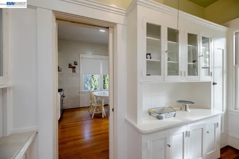 a view of a hallway with wooden floor and a bathroom