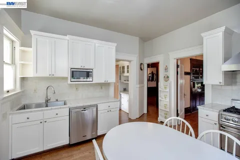 a large white kitchen with stainless steel appliances