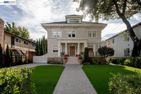 a front view of a house with a garden and plants