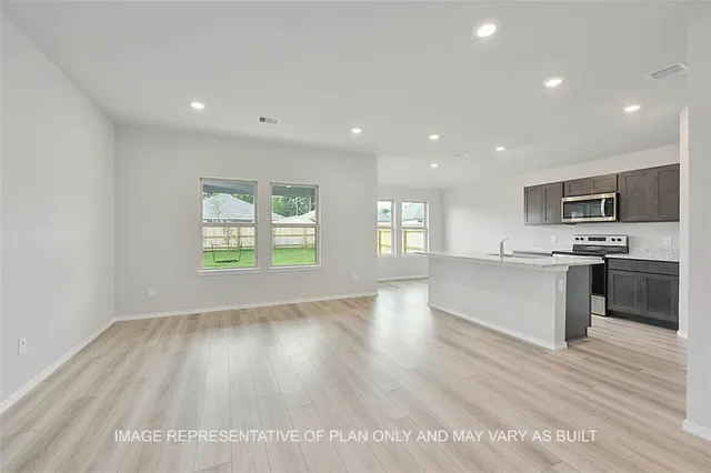 a view of kitchen with wooden floor and electronic appliances