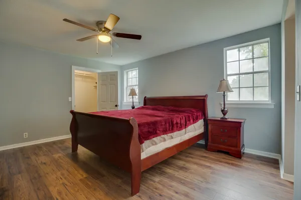 a bed sitting in a bedroom next to a window and a chandelier