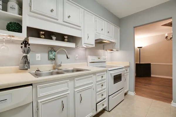 a kitchen with white cabinets and white appliances