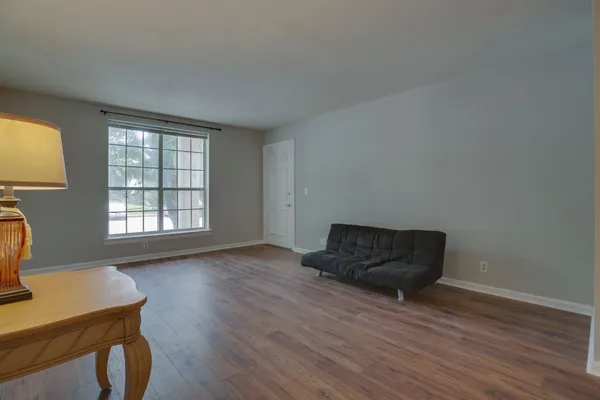 a living room with wooden floor and a window
