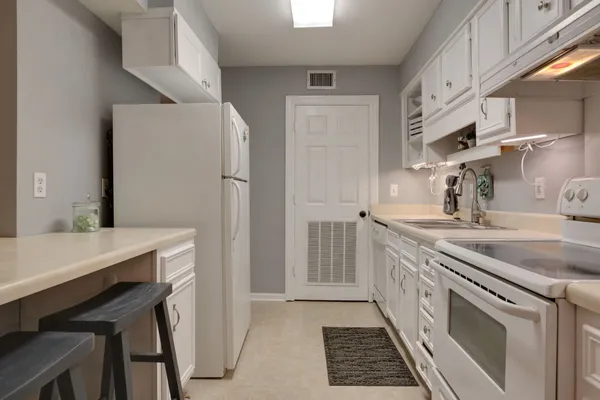 a kitchen with granite countertop a sink stove and cabinets