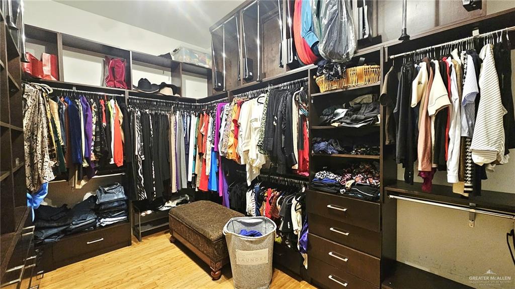 2213 South 48th Street McAllen, TX 78503 - Photo 17 of 28 a view of walk in closet with clothes and shoes