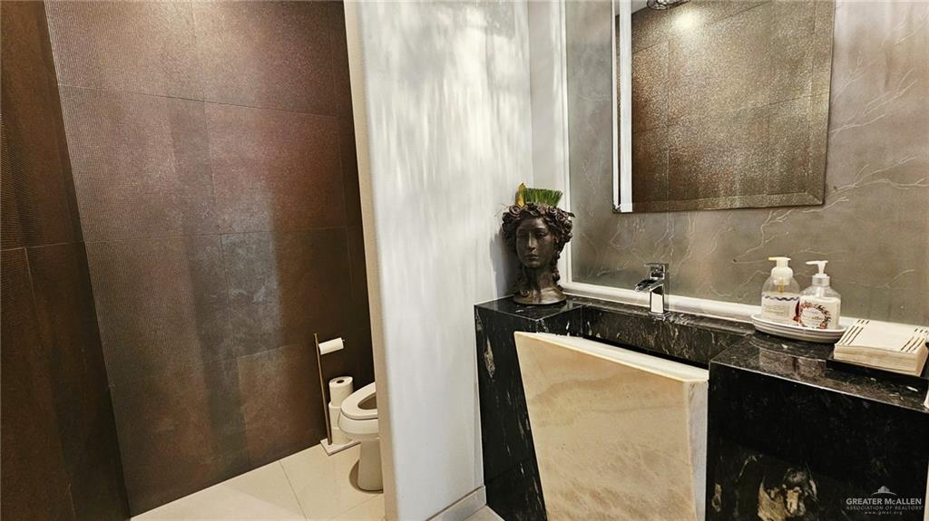 2213 South 48th Street McAllen, TX 78503 - Photo 10 of 28 a bathroom with a granite countertop sink and a mirror