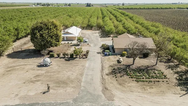 an aerial view of a house with a yard and lake view
